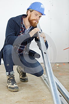 worker checking metal plank straightness