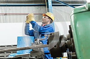 Worker checking quality behind an industrial machine