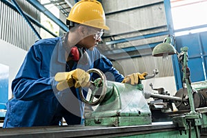 Worker checking quality behind an industrial machine