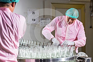 Worker Checking quality or checking stock of glass bottle in beverage factory. Worker QC working in a drink water factory