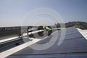 Worker Checking Solar Panels On Rooftop
