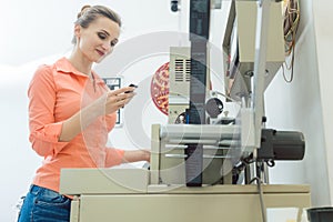 Worker checking textile label fresh from the printing machine