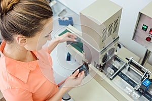 Worker checking textile label fresh from the printing machine