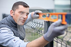 worker checks level metal fence