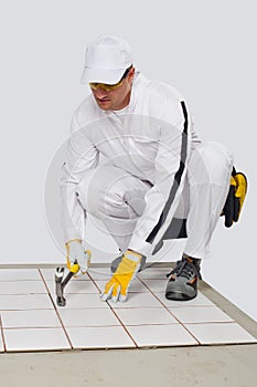 Worker checks old tiles base with hammer