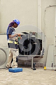 Worker cleaning air conditioner dust