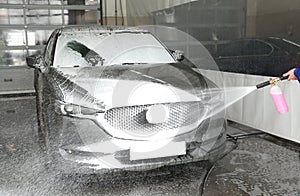 Worker cleaning automobil at car wash photo