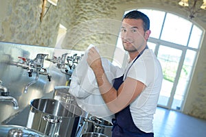 Worker cleaning barrel beer at brewery