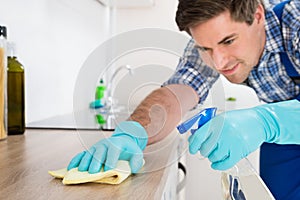 Worker Cleaning Countertop With Rag