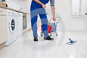 Worker Cleaning Floor In Kitchen Room