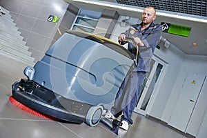 Worker cleaning floor with machine