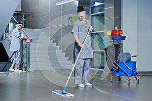 Worker cleaning floor with machine