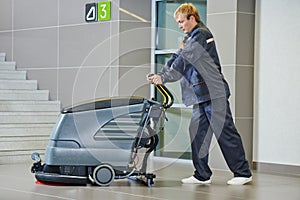 Worker cleaning floor with machine