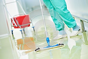 Worker cleaning floor with machine