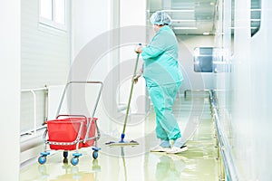 Worker cleaning floor with mop