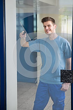Worker Cleaning Glass With Squeegee