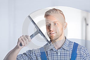 Worker Cleaning Glass Window With Squeegee