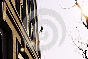 Worker cleaning outdoor windows service on high rise building