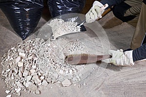 Worker cleaning rubble with brush and dustpan