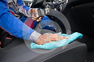 Worker Cleaning Seat Inside The Car