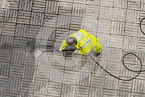 Worker cleaning a sidewalk with pressurized water