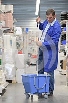 worker cleaning store floor
