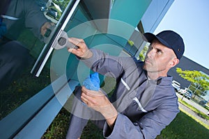 Worker cleaning windows service on high rise building