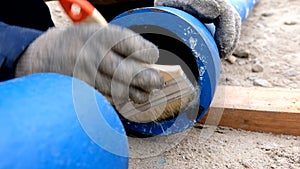 Worker cleans pipes for lubrication by brush