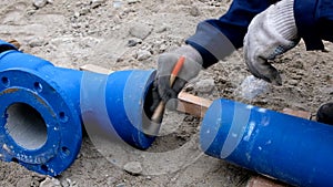 Worker cleans pipes for lubrication by brush