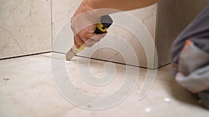 The worker cleans the seams of ceramic tiles. The technology of professional and highly skilled tile work. The tiler