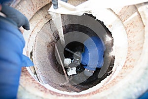 Worker cleans the sewer hatch.