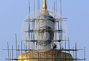 Worker renovates on buddha statue