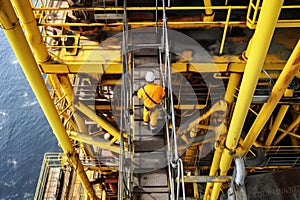 worker climbing ladder on board of offshore oil rig