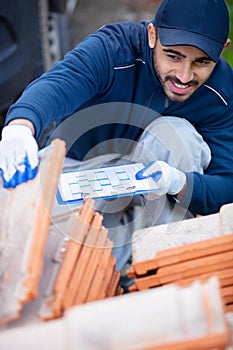 worker with clipboard checking construction materials