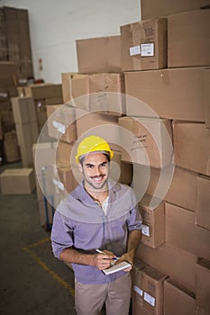 Worker with clipboard in warehouse