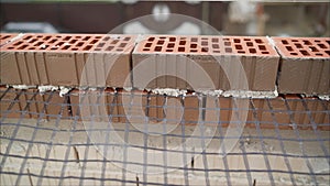 Worker in Close up of industrial bricklayer installing bricks and mortar cement brick on construction site. Worker