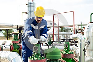 Worker closes the valve on the oil pipeline