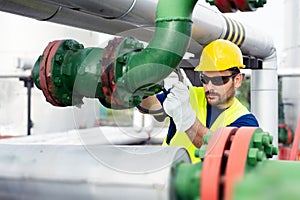 Worker closes the valve on the oil pipeline