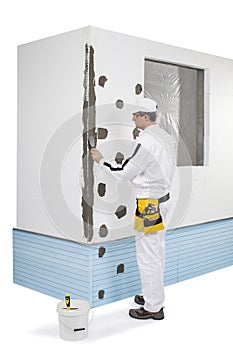 Worker coating a corner-lath with a putty