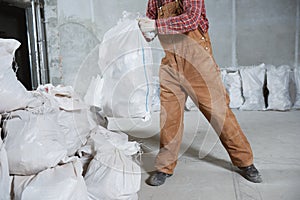 Worker collecting construction waste in bag