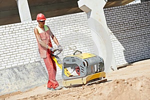 Worker with compaction machine photo