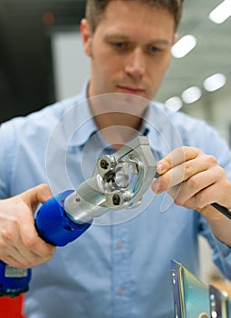 Worker compressing cable connector.