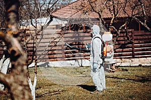 worker concept. Farmer spraying organic pesticides