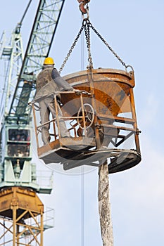 A worker in a concrete bucket