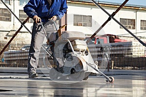 Worker with concrete cutting machine in motion