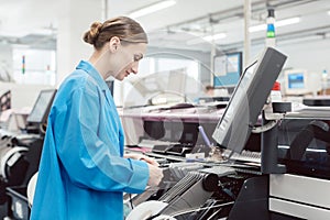 Worker confectioning electronic parts on assembly line