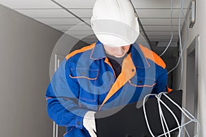 A worker configures a secure Internet in a building using a laptop, close-up photo