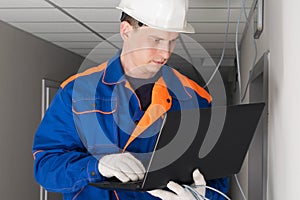 A worker configures the security of the network in the building photo