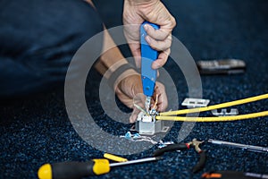 Worker connect a network cable with RJ45 sockets by punch-down tool, process of laying the local network. Set