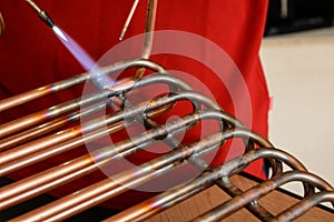 Worker connecting copper pipes - close-up photo